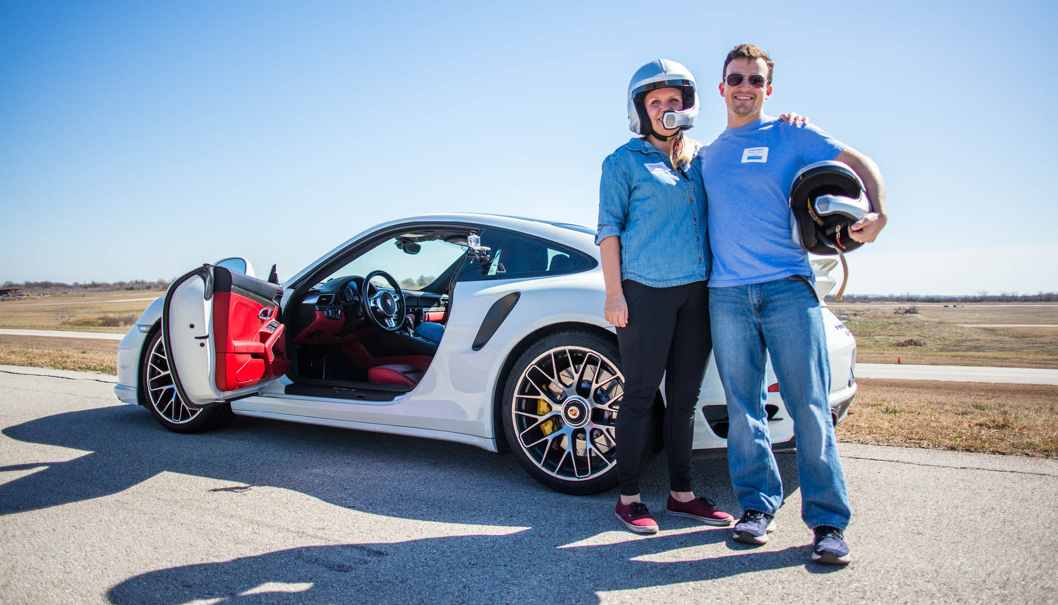 Happy couple driving Porsche racecar